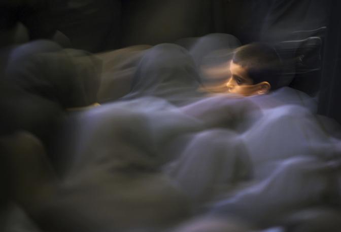 Maggio 2001: un bambino iraniano in mezzo a un gruppo di donne durante la preghiera del mattino in una moschea a Teheran (Damir Sagolj/Reuters)