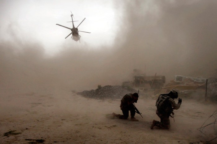 Soldiers with the U.S. Army's 1-320 Field Artillery Regiment, 101st Airborne Division shield themselves from the dust as a Medevac helicopter takes off outside Combat Outpost Nolen in the Arghandab Valley north of Kandahar July 30, 2010. One soldier lost his leg and another was hit by shrapnel after an Improvised Explosive Device (IED) blew up during a patrol near the base. (REUTERS/Bob Strong)