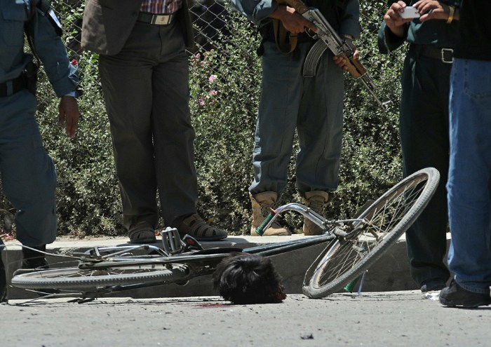 Afghan security personnel stand near the severed head of a suicide bomber at the site of a suicide attack in Kabul on July 18, 2010. A suicide bomber on a bicycle detonated explosives in central Kabul July 18, injuring six people, two days before a key international conference in the capital, a government official told AFP. (MASSOUD HOSSAINI/AFP/Getty Images)