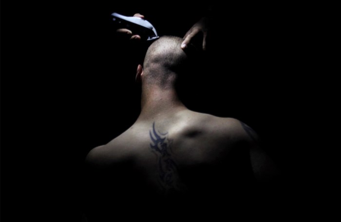 A United States soldier from Bravo Company, 2nd Battalion of the 508 Parachute Infantry Regiment of the 82nd Airborne, has his head shaved by the light of a flashlight at Combat Outpost Ware Sunday July 11, 2010, in Arghandab Valley, outside Kandahar City. (AP Photo/Kevin Frayer)